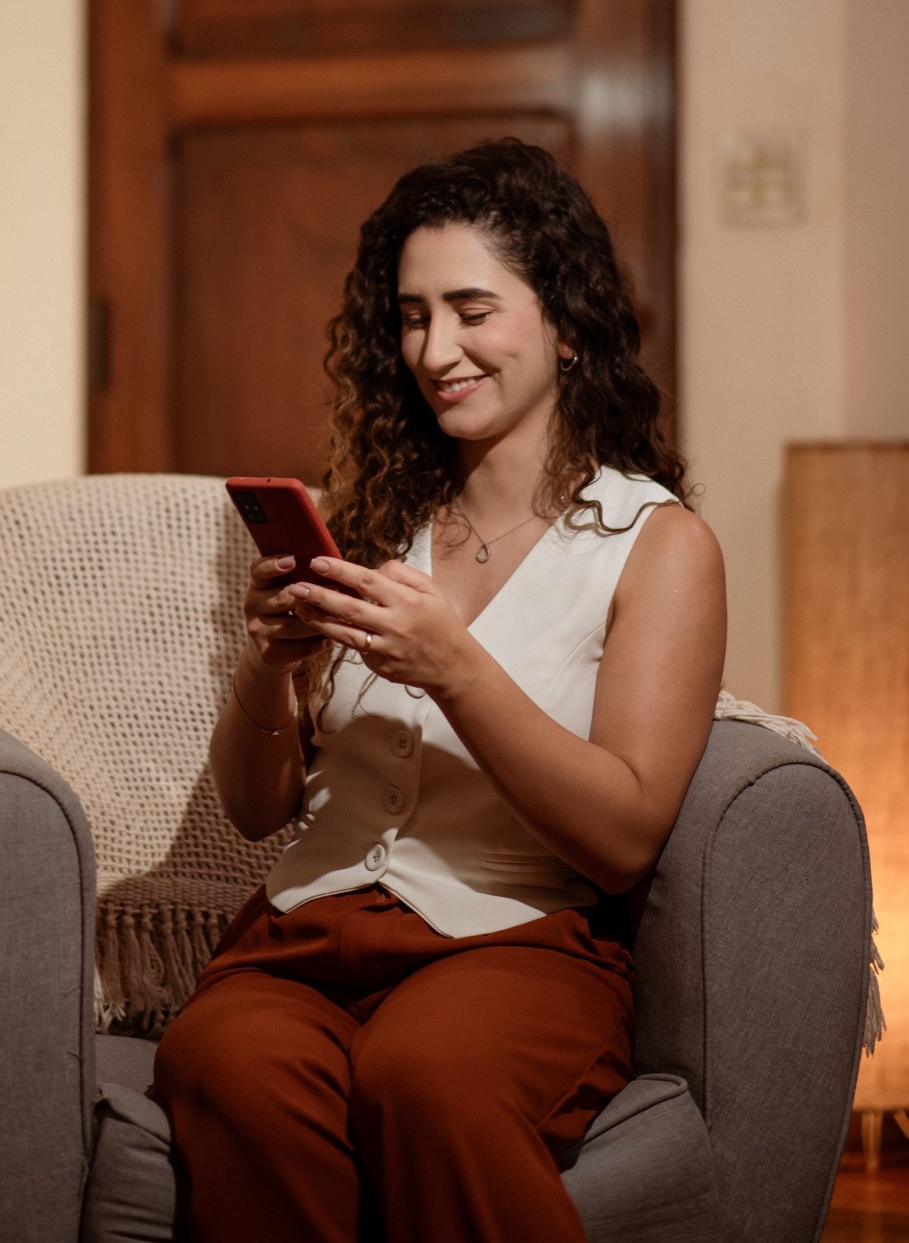 Sarah Calabrez sorrindo em um ambiente residencial aconchegante
